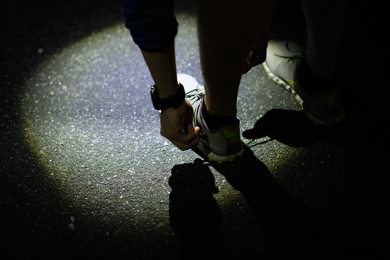 夜道で靴紐を結ぶ人